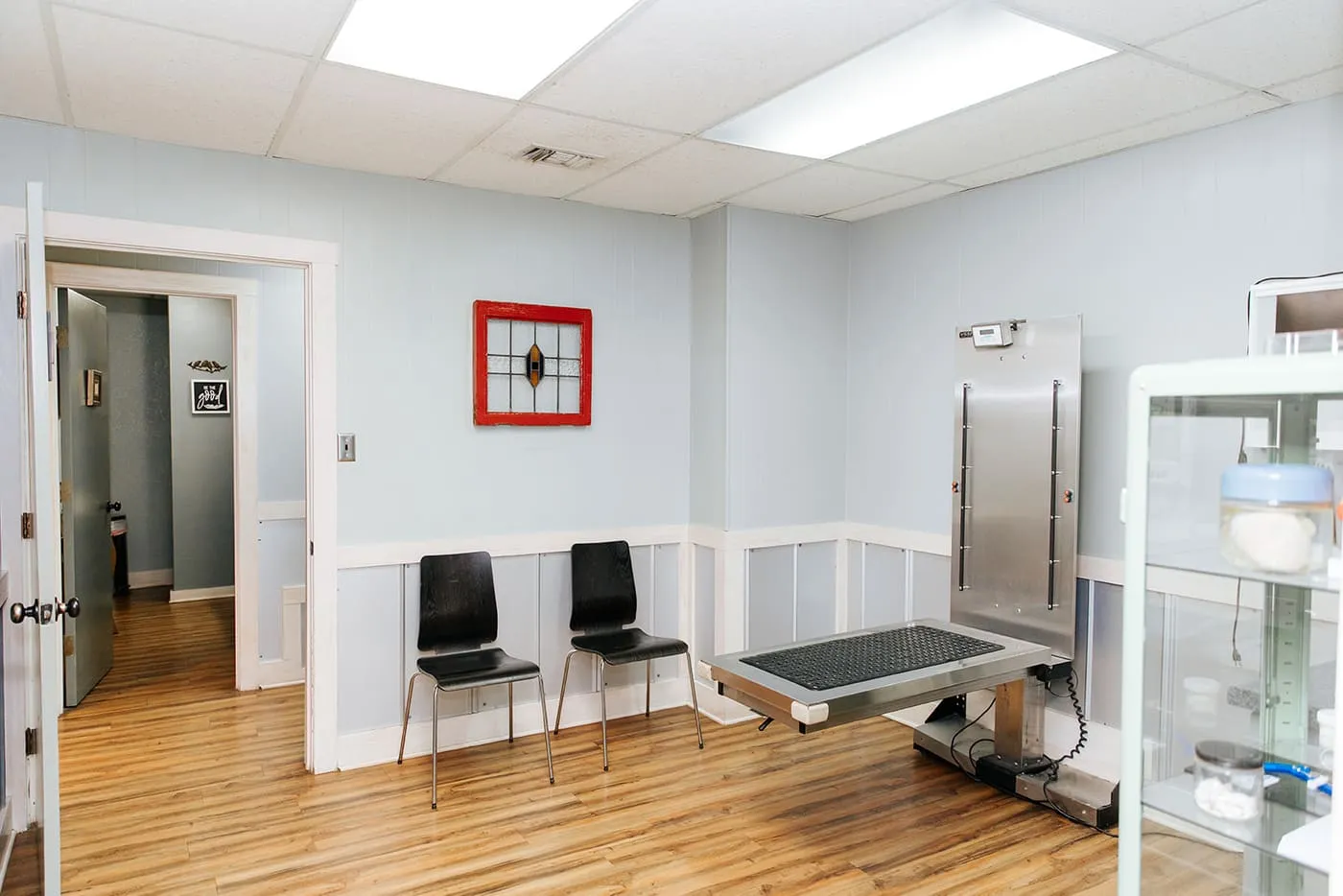 An exam room with a scale and seating